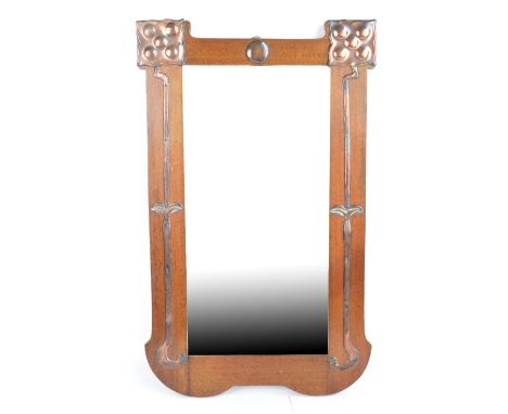 An Arts and Crafts mahogany and copper clad wall mirror of shaped rectangular form with bevelled plate, 64 x 40cm.   CONDITIO