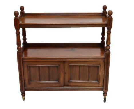 A late Victorian oak buffet, the raised top shelf above two cupboard doors raised on ring turned legs to brass caps and casto