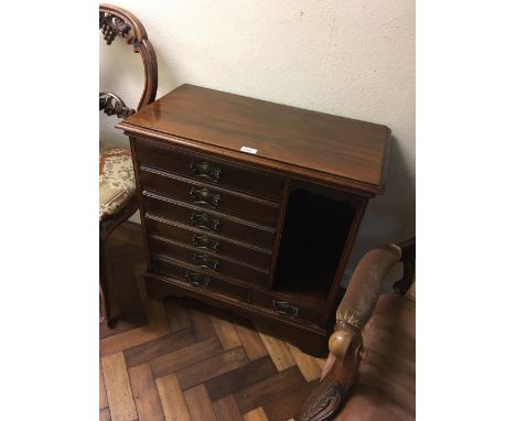 An Edwardian mahogany music cabinet with five drawers above two shorter examples and compartment to one side, on bracket feet