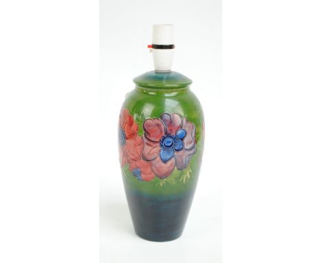 MOORCROFT; An "Anemone" pattern tube lined decorated baluster lamp base on green ground, impressed marks to base, height 34cm
