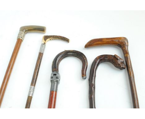 A George V hallmarked silver mounted antler handled riding crop, a white metal mounted horn handled walking stick, two rustic