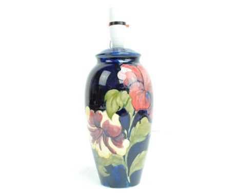 MOORCROFT; a tapering lamp base in the 'Hibiscus' pattern on blue ground with impressed mark to base and Royal Appointment la