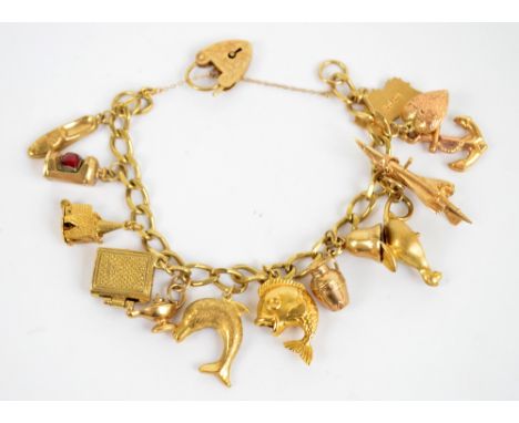 A 9ct yellow gold charm bracelet set with numerous charms including an anchor, fish, Aladdin's lamp etc, approx 37.2g.