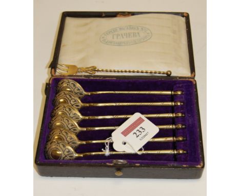 A cased set of six early 20th century Russian silver gilt and niello decorated spoons; together with a similar fork