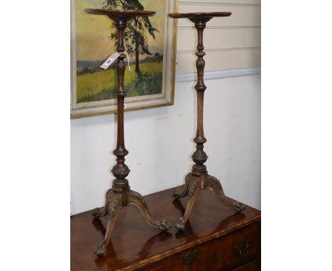 A pair of George I style carved mahogany tripod candle stands, Diameter 22cm, H.77cm