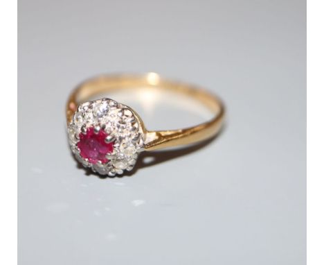 A mid 20th century yellow metal (stamped 18ct and Plat), ruby and diamond cluster ring, size L/M, gross 2.4 grams.CONDITION: 