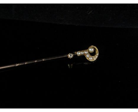 A gold stick pin stamped 18 with a seed pearl and diamond set question mark finial, 1.3g 