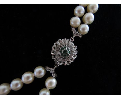 A double strand pearl necklace, 6mm pearls, 60cm long with an 18ct white gold emerald set clasp 