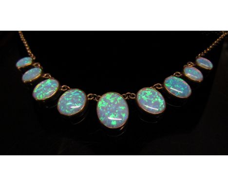 A 9ct gold necklace with nine graduated oval opal drops, 44cm long, 10.7g 