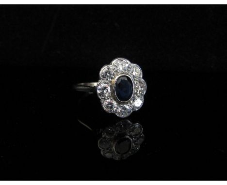 A white gold sapphire and diamond cluster ring, 0.80ct approx total diamonds, stamped 18ct, rubbed. Size R, 3.6g 