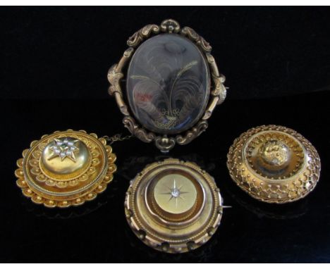 Four Victorian memoriam brooches including unmarked gold, woven hair examples, one set with emerald and pearl, another with c