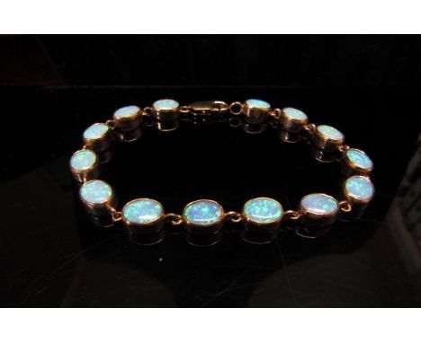 An opal bracelet, with fourteen oval opal links, stamped 375, 19cm long, 11.8g 