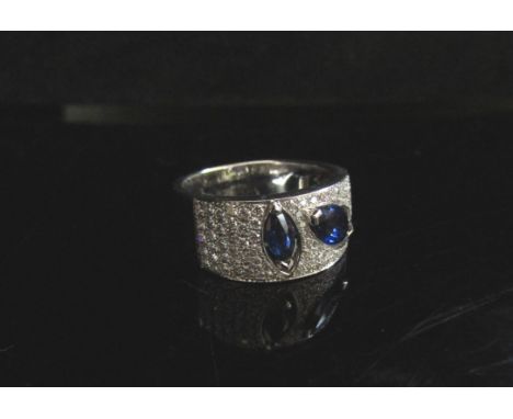 A modernistic 18ct white gold sapphire and diamond ring. Size N/O, 8.8g 