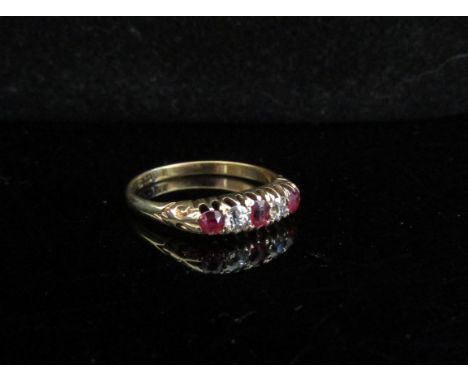 An 18ct gold five stone ruby and diamond ring. Size Q/P, 3g 