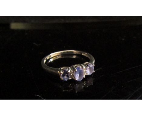 A 9ct white gold ring set with three tanzanites and diamond chips. Size O, 1.7g 