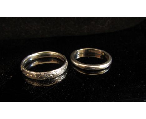 Two platinum bands, one engraved example. Sizes K and J, 7.6g 