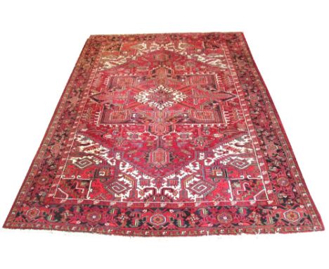 HERIZ CARPET, 357cm x 258cm, of an ivory and ruby medallion on ruby field, ivory spandrels and sapphire border.