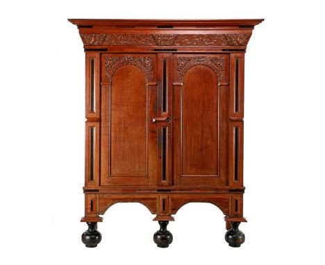 Oak gate cabinet with blackened accents, standing on ball feet and decorated with carved decor on the doors and in the frieze