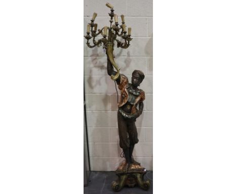 A mid 20th century blackamoor floor standing lamp, the figure grasping a cornucopia from which the eight-sconce electrolier p