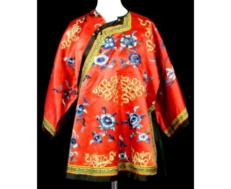 A Chinese embroidered jacket, mid 20th century, the red ground detailed with blue lotus threads and traditional motifs, the e