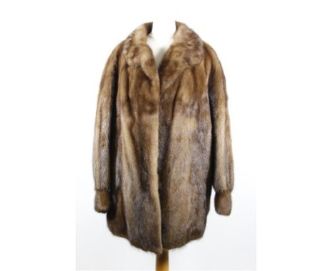 A late 1950's/1960's light brown mink swing coat, three quarter length with self lined collar, triple hook fastening to front