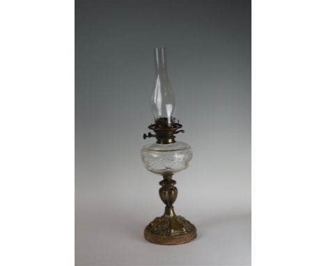 A late Victorian cut glass oil lamp, the cast metal floral moulded socle base, rising to a bud form knopped stem, the central