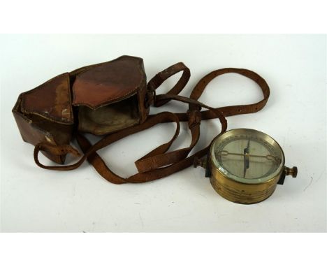 An early 20th Century brass bound surveyors compass, of circular form within an incised brass casing and glass face, with sil
