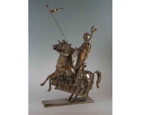 A 20th Century stylised white metal figure of a jousting Knight, the stylised figure in full armour with jousting stick held 