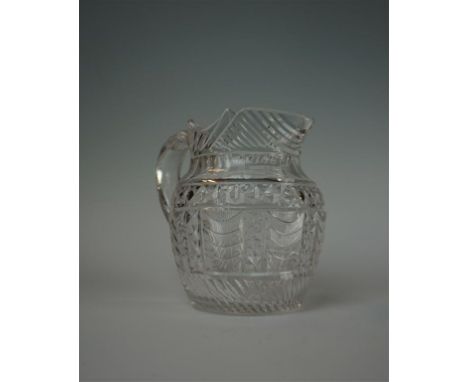 A Regency cut glass water jug, early 19th Century, of tapered ovoid form with loop handle, and scalloped rim, the clear glass