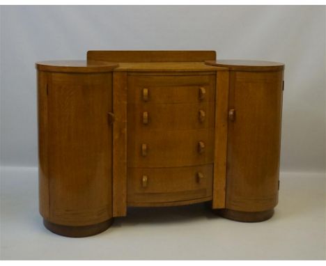 A Gordon Russell style circa 1930s Art Deco light oak sideboard, having two column cupboards flanking four drawers, length 13