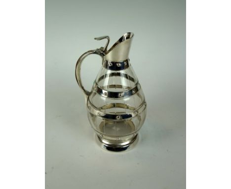 An early to mid 20th Century silver-plated and cut glass decanter of baluster form, having silver-plated banding and mounts i
