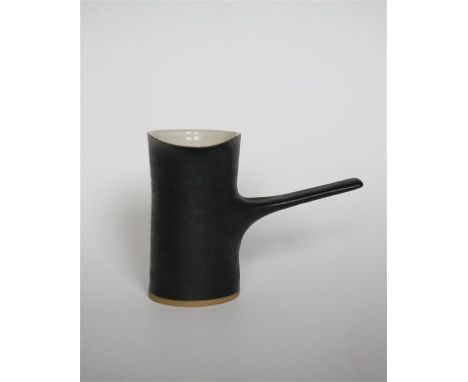 A Dame Lucie Rie (1902-1995) pouring jug with side handle, circa 1960, with manganese glaze and white interior, height 13cm (