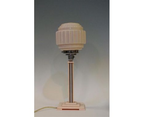 A 1930's Art Deco table lamp, the bakelite base having linear decoration on a stepped plinth base, with pink glass shade with