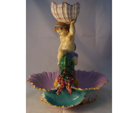 A late 19th Century George Jones Majolica centre piece, modelled with winged putti supporting a central open shell, raised on