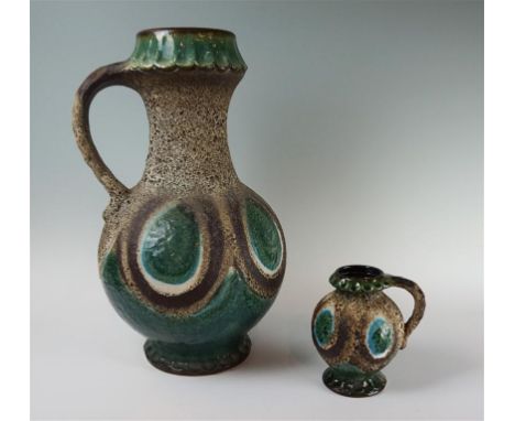 A Dumler & Brieden west German Fat Lava ceramic single handled vase, having green glazed decoration on a lava ground, factory