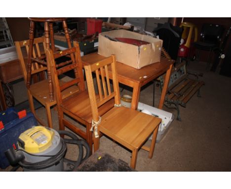 A square pine table with three chairs and a beech stool