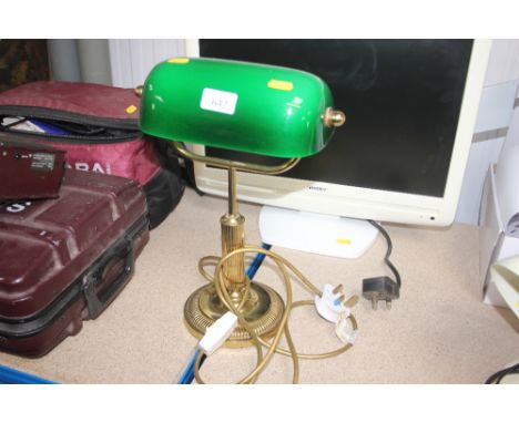 A brass desk lamp with green glass shade