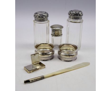 Pair of engraved silver serviette rings, cased, Birmingham 1921, 3 glass dressing table jars with silver covers, silver stamp