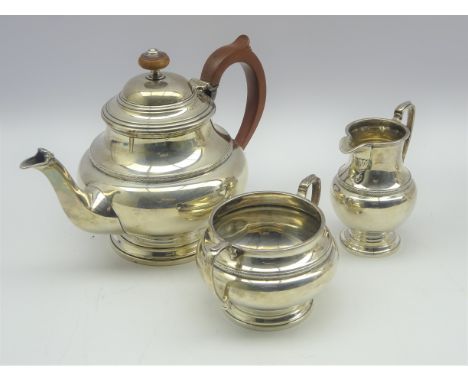 Silver three piece tea set of circular design, the teapot with stained handle and lift, Birmingham 1932 maker Harrods Ltd 24.