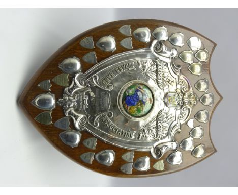 Huddersfield and District Brass Band Association - A silver mounted oak shield with an enamel centre panel and surrounded by 