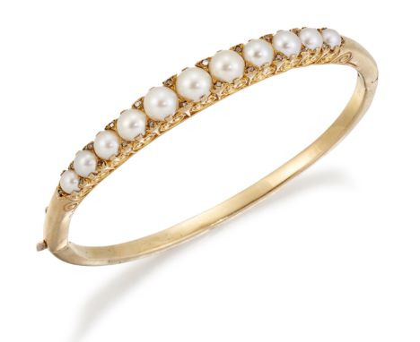 A LATE VICTORIAN SPLIT PEARL AND DIAMOND BANGLE, graduated split pearls spaced by diamond accents within carved settings, to 