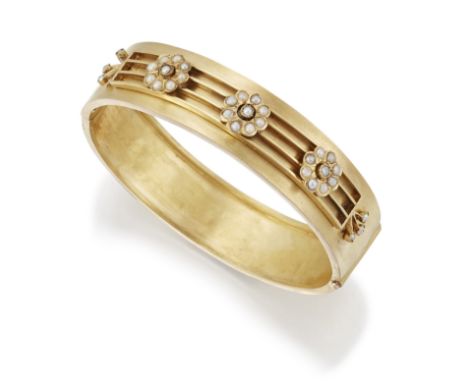 A LATE 19TH CENTURY SPLIT PEARL BANGLE, three flowerhead clusters set with split pearls to a knife-edge bar frame, the revers
