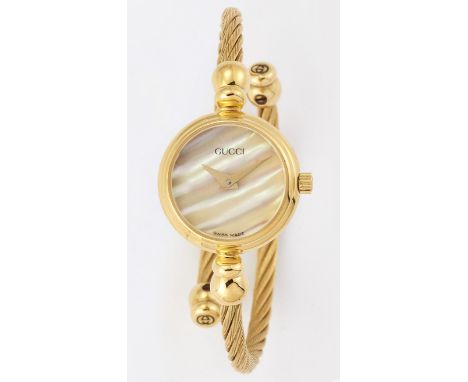 A LADY'S GOLD-PLATED GUCCI BANGLE WATCH,&nbsp;circular mother-of-pearl dial with gilt sword hands, dial signed Gucci, twisted