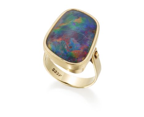 AN OPAL DOUBLET RING, an irregularly shaped opal doublet in a bezel setting above a tall under bezel, to pinched shoulders, m