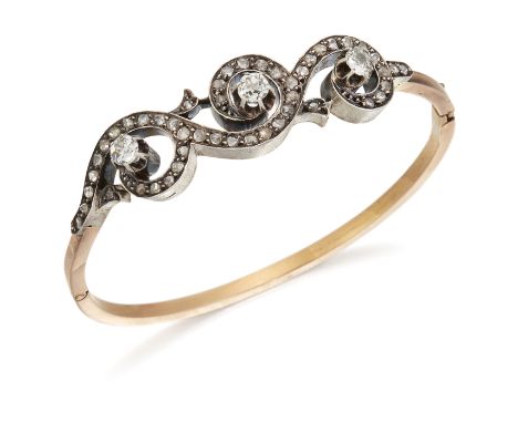 A LATE 19TH CENTURY DIAMOND BANGLE, three old-cut diamonds within diamond set scrolls, to a plain hinged bangle, total estima