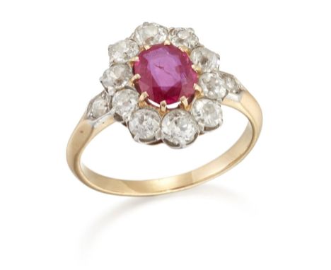 AN EARLY 20TH CENTURY RUBY AND DIAMOND CLUSTER RING, an oval-cut ruby within a border of old-cut diamonds, to diamond set ang