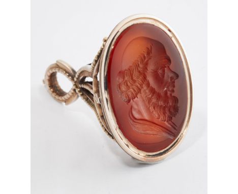 A CARNELIAN INTAGLIO FOB SEAL, the oval carnelian carved depicting the profile of a gentleman, to a fancy scroll mount. Seal 