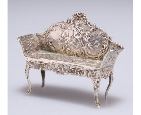 A GERMAN SILVER MINIATURE MODEL OF A SETTEE,&nbsp;import marks, Berthold Muller, London 1896, chased with musical putti and r