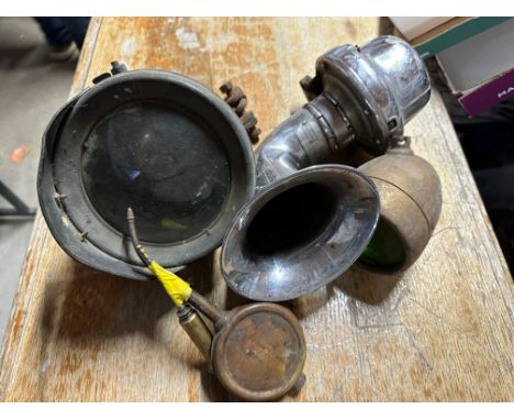 An Edwardian acetylene lamp, an early electric horn, a pair of oilers and a side lamp. 