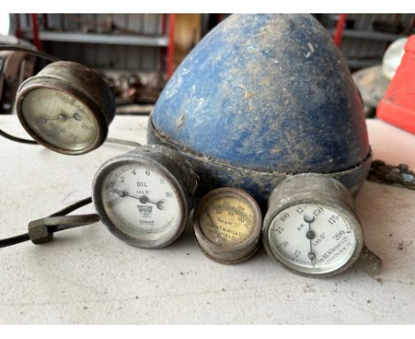 A large headlamp and four pressure gauges. 